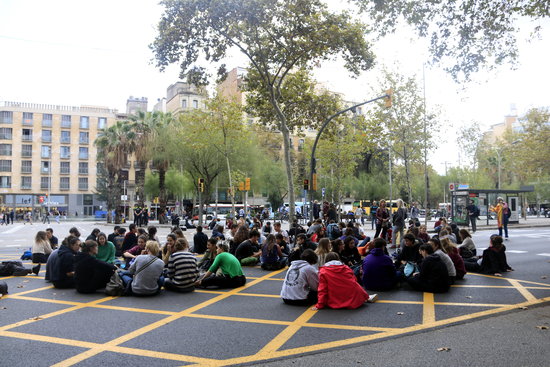 Students block a road on Plaça Universitat in front of the historic University of Barcelona building (by Laura Fíguls)