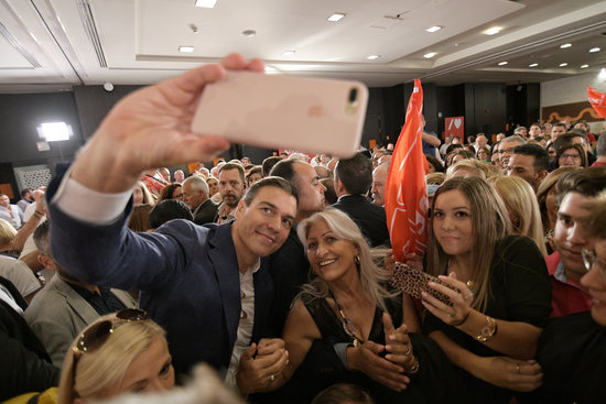 Pedro Sánchez takes a selfie with Spanish Socialist Party supporters at a campaign act (by Inma Mesa / PSOE)