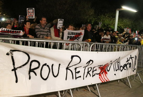 Protesters stand behind a banner that reads “Enough repression, freedom!” (by Norma Vidal)