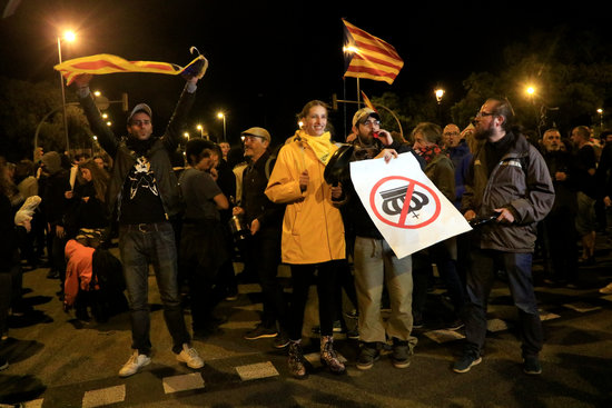 Pro-independence protesters holding signs against the Spanish monarchy (by Laura Fíguls)