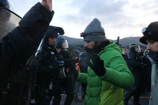 A protester standing in front of French police officers (by Gerard Vilà)