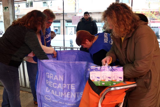 A shopper gives donations to volunteers in a supermarket during the 2019 'Gran Recapte' food drive (by Elisenda Rosanas)