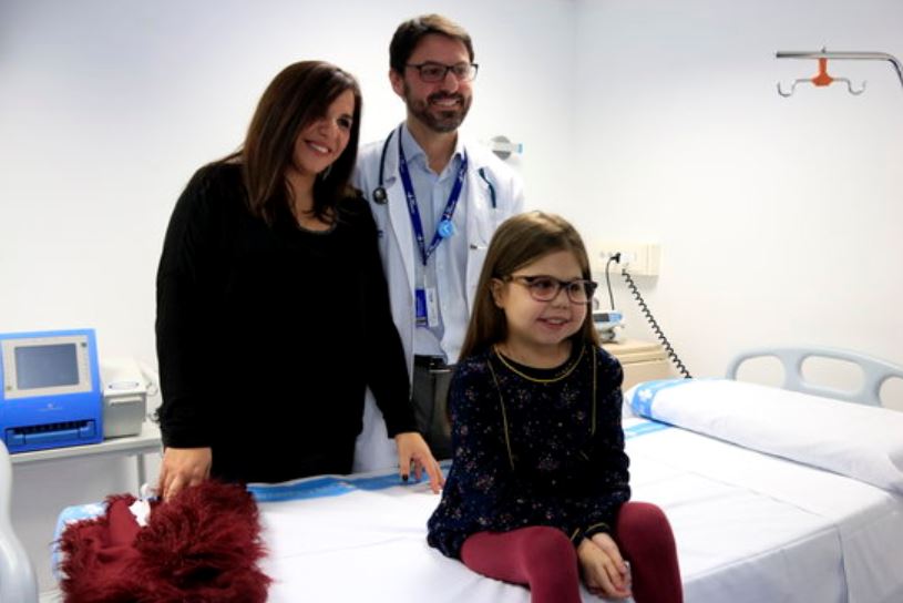 Iria, the longest survivor of a rare genetic mutation, poses with her mother and doctor Jesús Quintero at Barcelona's Vall d'Hebron hospital (by Laura Fíguls)
