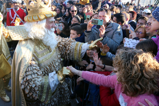 Melchior, one of the three magic kings, greets parade-goers on the night before King's Day (by Miquel Codolar)