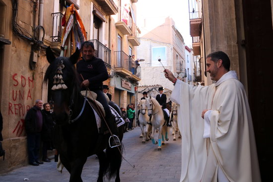A man riding a horse being blessed by a priest from the church of Saint Anthony in Valls during the Tres Tombs festival on January 12, 2020 (by Mar Rovira)
