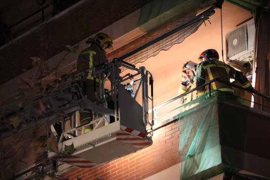 Firefighters assist one of the neighbors in the building hit by the piece of metal thrown off from the explosion at the chemical plant in southern Catalonia (by Núria Torres)