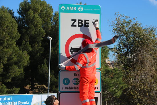 Workers installing a ZBE sign in Hospitalet, December 23, 2019. (by Àlex Recolons)