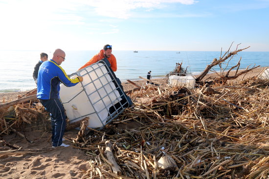 Volunteers removing a large plastic container from Malgrat de Mar beach on February 2, 2020 (by Àlex Recolons)
