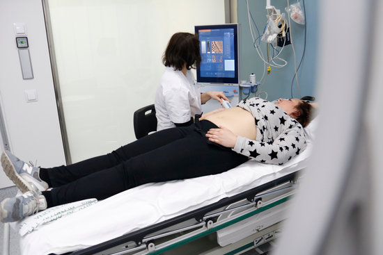 A doctor performes a liver screen on a patient in Hospital Clinic (by Blanca Blay)