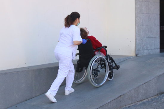 A home care worker takes care of an elderly person in a wheelchair (by Eloi Tost)