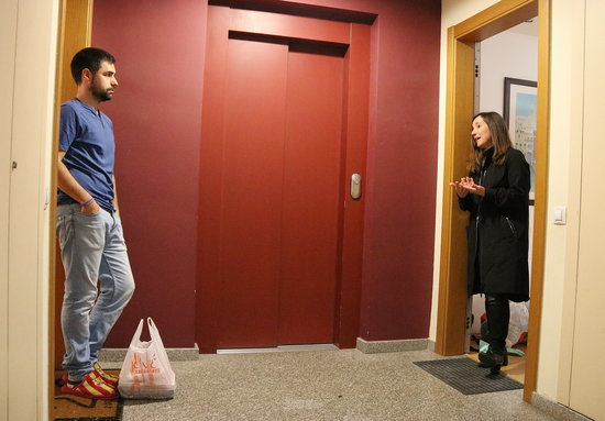 Two neighbours chatting in an apartment building in Sabadell where the community have started an initiative to buy shopping for vulnerable neighbours (by Norma Vidal)