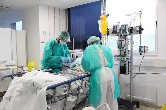 Two doctors and a Covid-19 patient in Girona's Hospital Tueta, on April 18, 2020 (by Hospital Trueta)