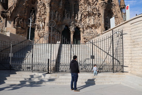 A parent and child out for a walk in front of the Sagrada Familia after confinement restrictions on children leaving the house were lifted on April 26, 2020 (by Mar Vila)