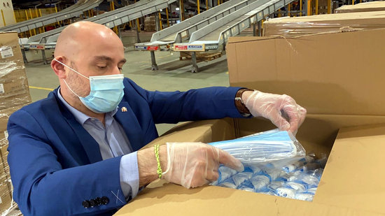 A Spanish government worker managed boxes of face masks before they were sent to regions (image by Moncloa)