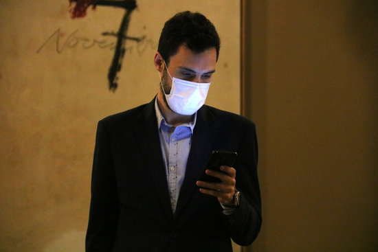 Catalan parliament speaker Roger Torrent wearing a face mask and using his mobile phone (by Bernat Vilaró)