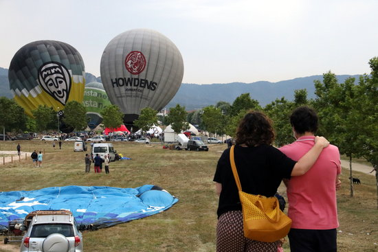 A couple look on as hot air balloons are inflated in Igualada, July 10, 2020. (by Mar Martí) 