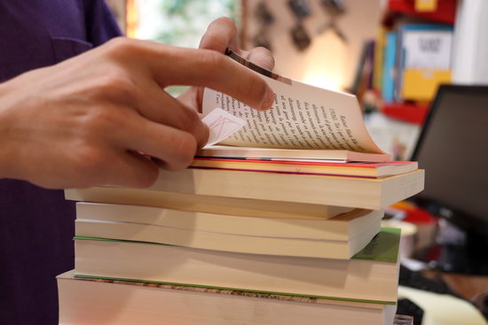 A bookshop owner labelling a pile of books in Barcelona, on July 22, 2020 (by Mar Vila)