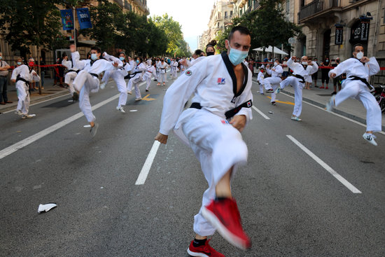 A group of people perform martial arts during a sports demonstration in the middle of Barcelona (by Miquel Codolar)