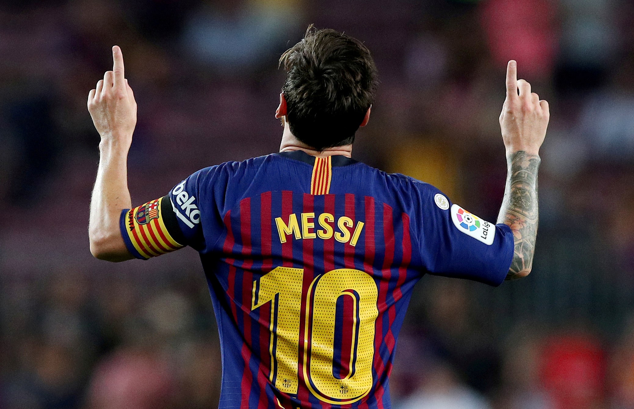 Lionel Messi raises in hands in the air in celebration after scoring a goal (by REUTERS/Albert Gea)