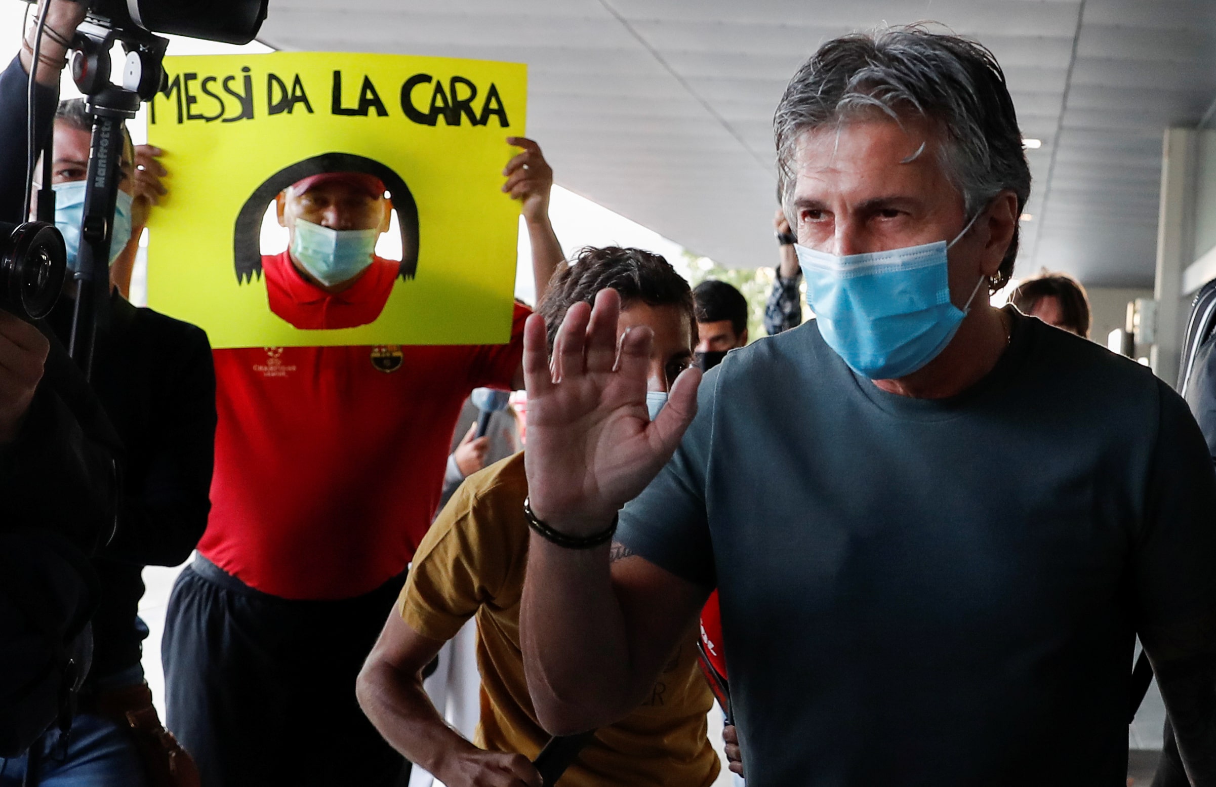 A Barça fan holds up a sign reading “Messi, show your face” as the player's father and representative arrives at Barcelona airport for talks with the club (by REUTERS/Nacho Doce)