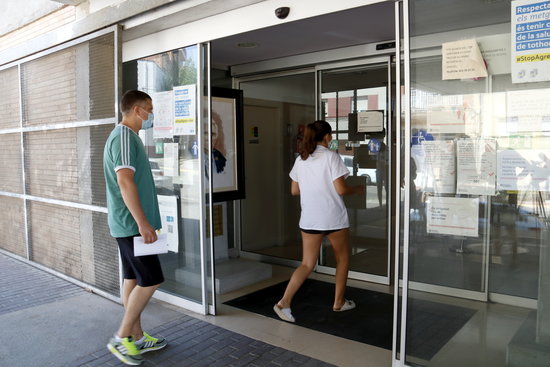 Two people entering the primary care CAP center in Alcarràs, western Catalonia, on July 29, 2020 (by Laura Cortés)