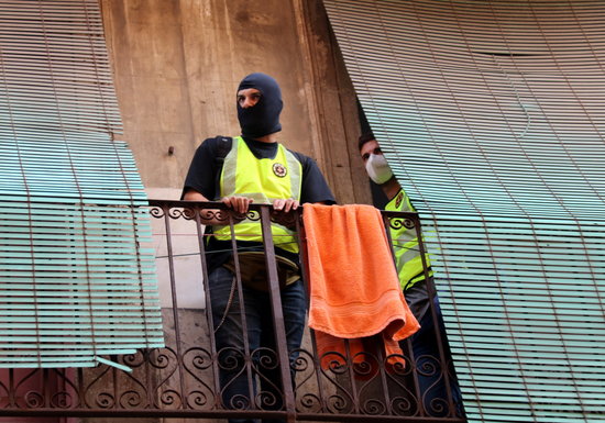 Two policemen on a balcony during the raid on Raval October 7, 2020 (by Miquel Codolar)
