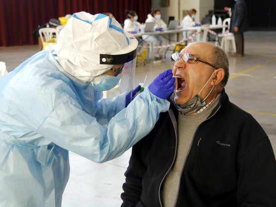 A medical professional performs a PCR test on a man (by Anna Berga)