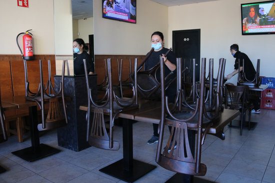 Bar El Toc, in Vilobí d'Onyar, tidying up chairs after ban on October 16, 2020 (by Gemma Tubert)