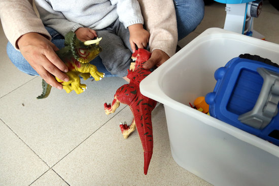 A survivor of gender-based violence playing with one of her children in a flat provided by support services on November 20, 2020 (by Gemma Tubert) 