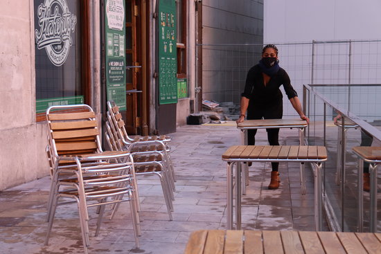 A waiter setting up a bar terrace in Barcelona's old town on November 23, 2020 (by Aina Martí)