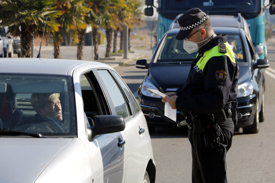 A police officer stopping a driver in Mollerussa to enforce Covid mobility restrictions (by Oriol Bosch)