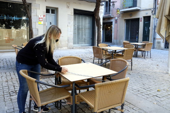A bar worker closes up a terrace in Santa Clara de Girona on November 23, 2020 (by Xavier Pi)
