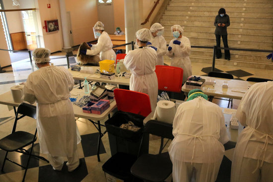 Several health workers performing rapid tests in a theater in Figueres, on November 30, 2020 (by Gemma Tubert)