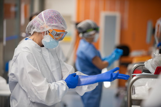 A staff member in Barcelona's Hospital Clínic ICU puts on protective gloves (Francisco Àvia/Hospital Clínic) 