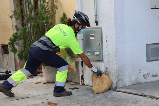 A worker for the public company Nora collects a bag (by Aleix Freixas)