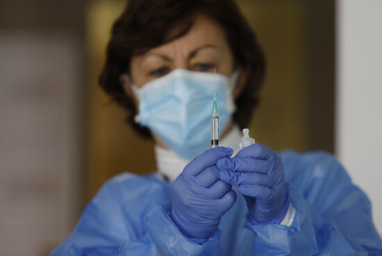 Image of a nurse holding a syringe containing a Pfizer Covid-19 dose, on December 30, 2020 (by Catalan health department)