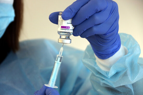 A medical professional prepares a syringe with a Covid-19 vaccine (by Roger Segura)