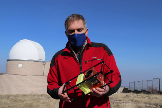 Josep Colomé, director of the Montsec Astronomical Observatory holds a model of a nanosatellite (by Alan Ruiz Terol)