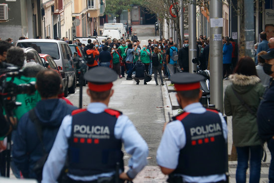 Two Mossos (Catalan police) officers observe activists protesting an eviction in Nou Barris, Barcelona, November 4, 2020 (by Blanca Blay)
