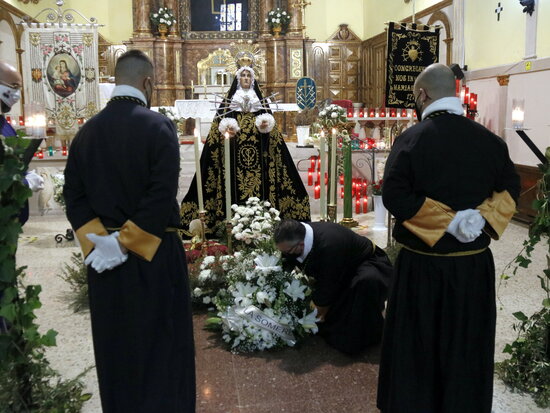 Three members of the Brotherhood of the Sagrada Familia and Saint Christopher make a floral offering to Lleida's Virgin of Sorrows, March 28, 2021 (by Anna Berga)
