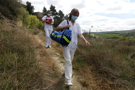 Health professionals walking on a rural pathway delivering vaccines to the village of Ivorra in central Catalonia (by Oriol Bosch)