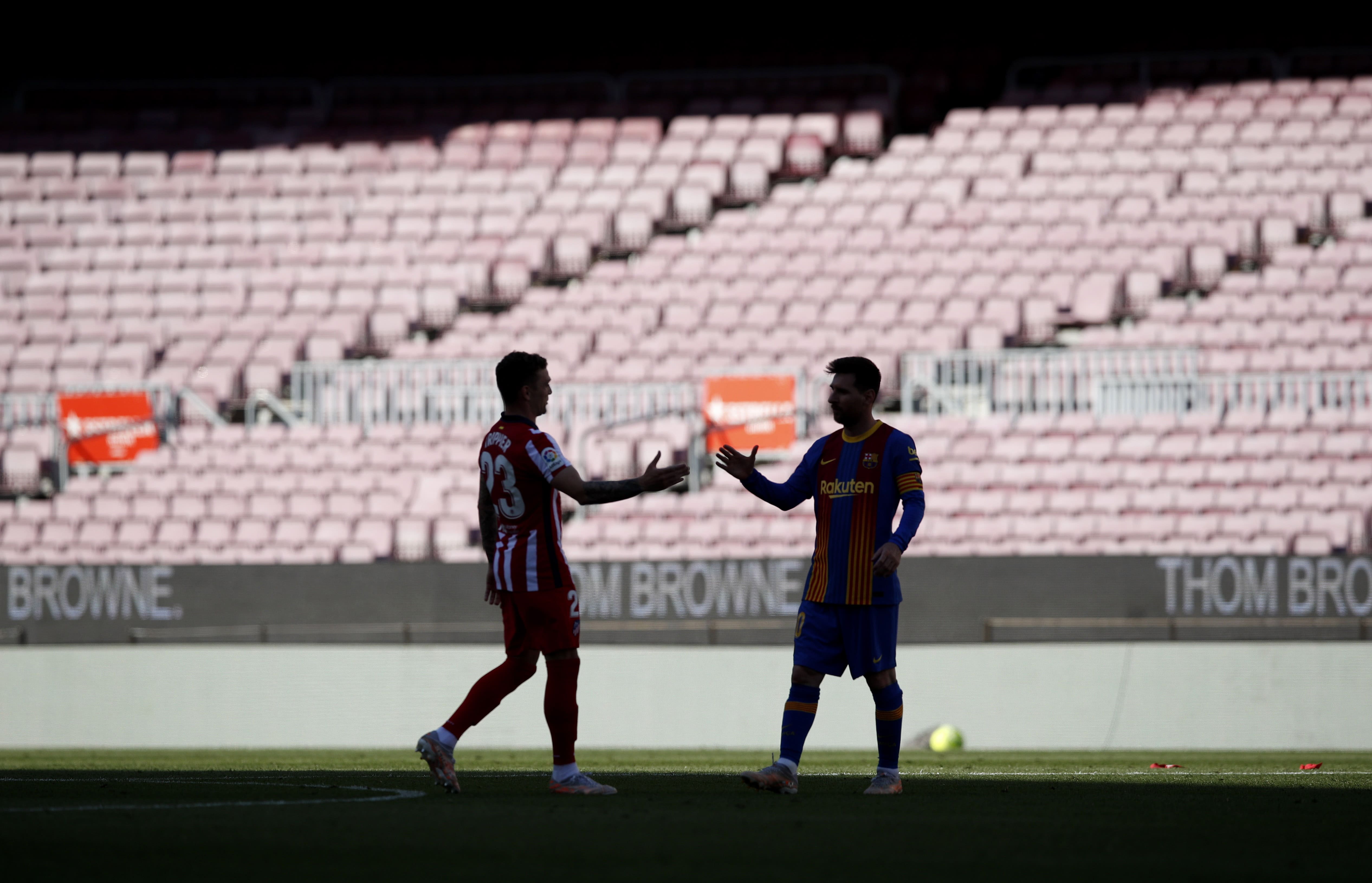 Barça's Leo Messi and Atleti's Kieran Trippier shake hands in front of an empty Camp Nou ahead of their La Liga clash (by REUTERS/Albert Gea)