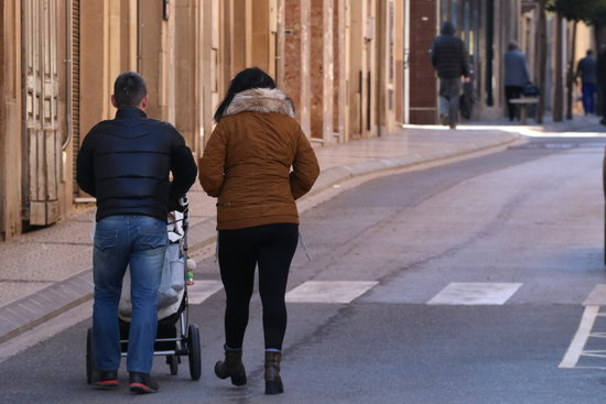 A couple with a pram walking through the town of L'Espluga de Francolí, March 29, 2018 (by Núria Torres)