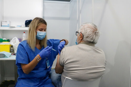 A health professional administers a Covid-19 vaccine in the Fira de Barcelona exhibition centre, being used as a mass vaccination site (by Blanca Blay)