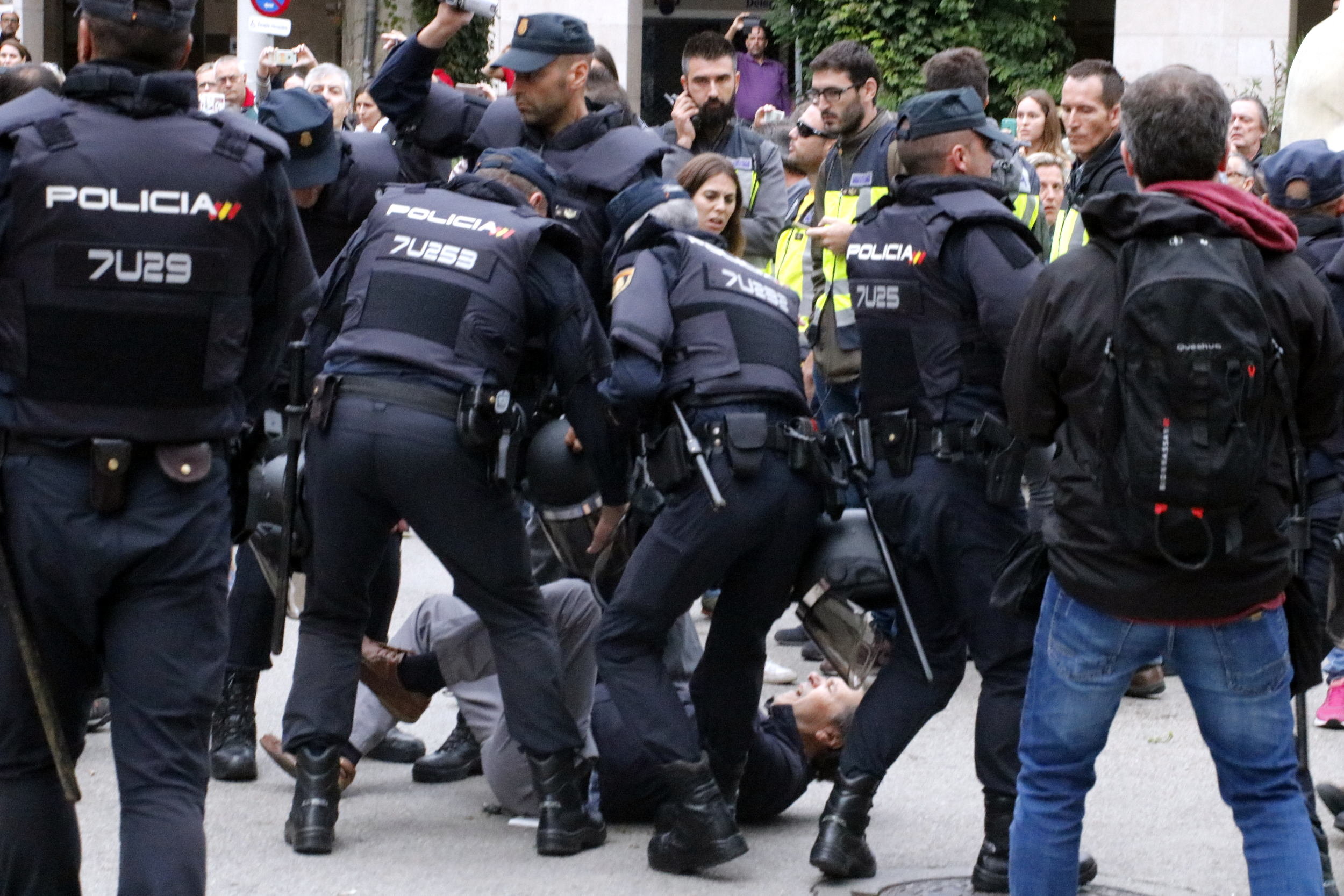 Spanish police surround a man on the ground during the independence referendum, October 1, 2017