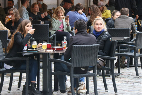 A group of people sit outdoors at a restaurant in Girona (by Gerard Vilà)