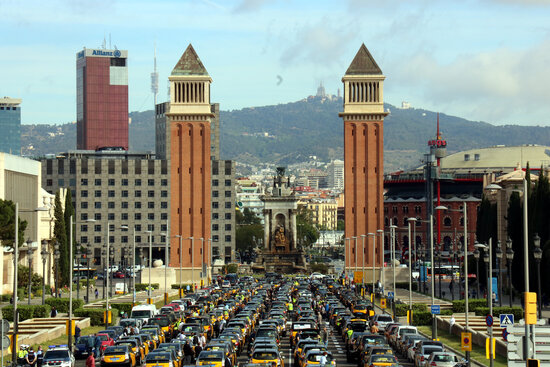 Taxis approach Barcelona's Plaça d'Espanya on their slow-drive protest to Plaça Sant Jaume, May 20, 2021 (by Lluís Sibils)