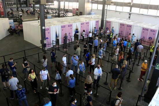 Image of some vaccination booths and a line in the Fira Barcelona vaccination site, on June 7, 2021 (by Laura Fíguls)