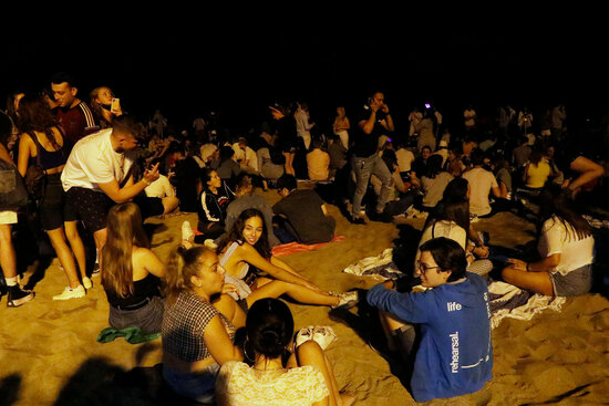 Young people celebrating the eve of Sant Joan on Barceloneta beach, June 24, 2021 (by Arnald Prat)