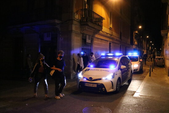 Two police cars patrol Barcelona's Gràcia neighborhood after the curfew is lifted on May 9, 2021 (by Sílvia Jardí)